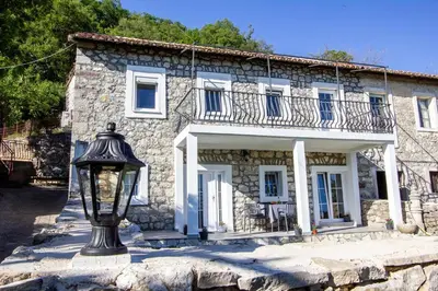 a stone house with a street light in front of it at Apartmani Stone oasis in Zupci