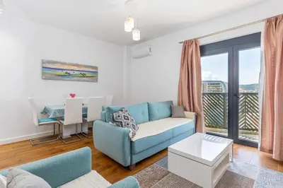 a living room with a blue couch and a balcony at Adriatic Harmony in Bar