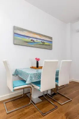 a dining room table and chairs with a painting on the wall at Adriatic Harmony in Bar