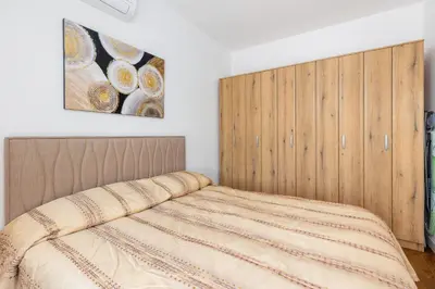 a bedroom with a bed with a wooden headboard at Adriatic Harmony in Bar