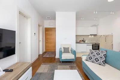 a living room with a blue couch and a kitchen at Adriatic Harmony in Bar
