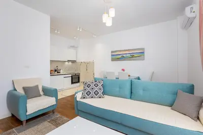 a living room with a blue couch and a chair at Adriatic Harmony in Bar
