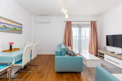 a living room with a blue couch and a tv at Adriatic Harmony in Bar