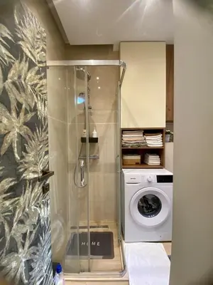 a shower in a bathroom with a washing machine at City Center 1 in Podgorica