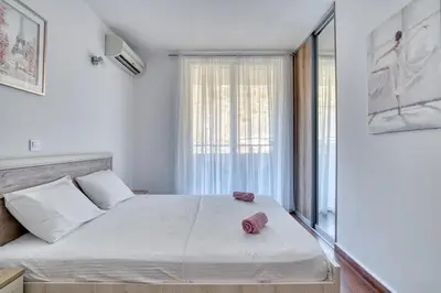 a bedroom with a large white bed with a window at Seabreeze Rafailovici in Rafailovici