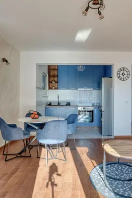 a kitchen with blue cabinets and a table and chairs at Seabreeze Rafailovici in Rafailovici