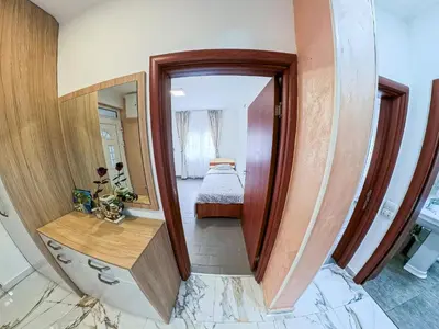 a hallway with a mirror and a bed in a room at Tivat Garden Apartments - Near Airport & Beach, Quiet Stay in Tivat