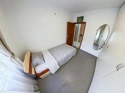 a small bedroom with a bed and a phone at Tivat Garden Apartments - Near Airport & Beach, Quiet Stay in Tivat