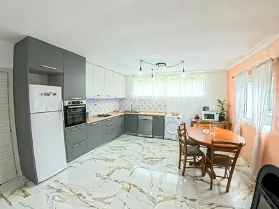 a kitchen with a table and a white refrigerator at Tivat Garden Apartments - Near Airport & Beach, Quiet Stay in Tivat