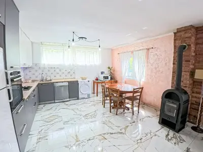 a kitchen with a table and a stove at Tivat Garden Apartments - Near Airport & Beach, Quiet Stay in Tivat