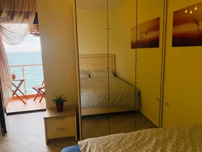 a bedroom with a bed and a view of the ocean at Emerald Dreamscape with Private Beach & Pool in Dobra Voda