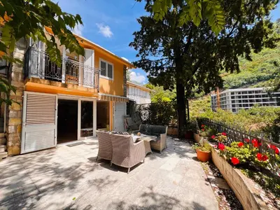 a patio with a table and chairs in front of a house at La Lumiere Perazica Do in Perazića Do