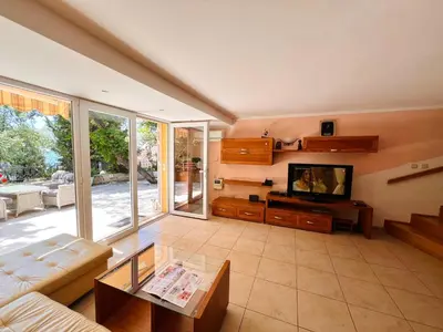 a living room with a couch and a tv at La Lumiere Perazica Do in Perazića Do