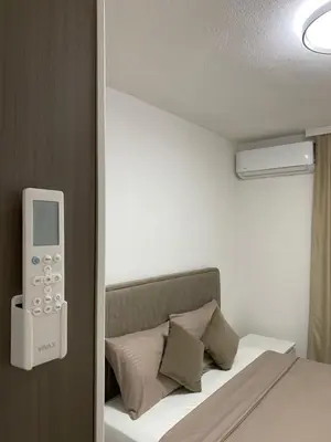 a bedroom with a bed with a remote control on the wall at Apartament Adian in Ulcinj