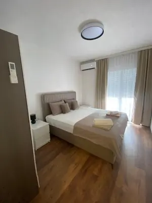 a bedroom with a large bed and a large window at Apartament Adian in Ulcinj