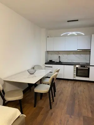 a kitchen with a table and chairs in a room at Apartament Adian in Ulcinj