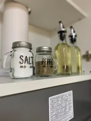 a counter with two glass jars on a shelf at Apartament Adian in Ulcinj