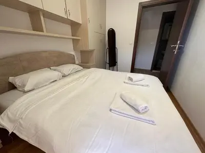 a white bed with two towels on top of it at Apartment ViSi 101 in Budva