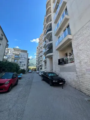 a black car parked on a street next to a building at Apartment ViSi 101 in Budva