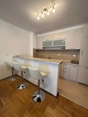 a kitchen with a counter and two bar stools at Apartment ViSI 102 in Budva