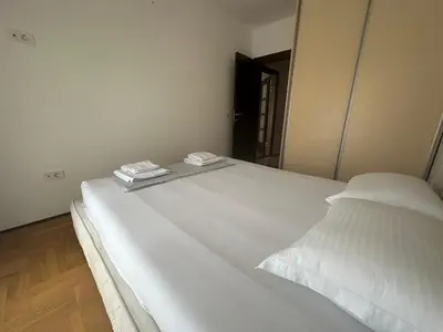a white bed with two pillows on top of it at Apartment ViSI 102 in Budva
