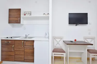 a kitchen with a sink and a table with a tv at Apartments Ivanovic in Budva