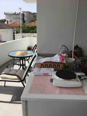 a balcony with a table and a grill on a table at NIDA Apartment in Ulcinj