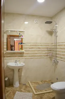 a bathroom with a sink and a toilet and a mirror at NIDA Apartment in Ulcinj