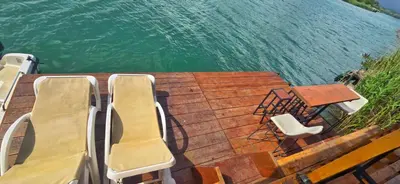 two chairs and a table on the deck of a boat at River house Una in Kravlja
