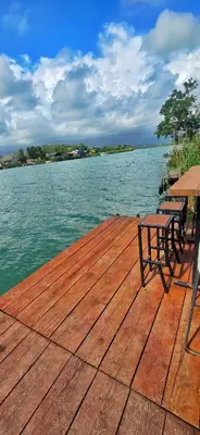 a wooden dock with benches and a table on the water at River house Una in Kravlja