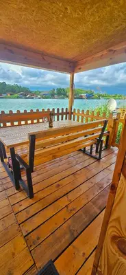 a wooden bench on a deck with a view of the water at River house Una in Kravlja