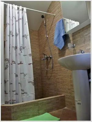 a bathroom with a shower curtain and a sink at Sailor House in Budva