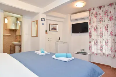 a bedroom with a blue bed and a television at Sailor House in Budva