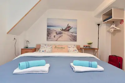 a bedroom with a blue bed with two pillows at Sailor House in Budva