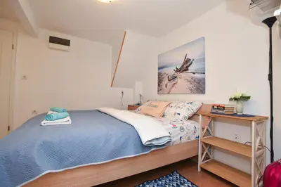 a small bedroom with a bed and a desk at Sailor House in Budva
