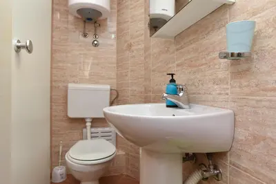 a bathroom with a white sink and a toilet at Sailor House in Budva