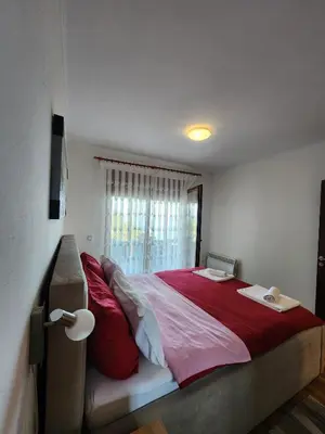 a bedroom with a large bed with red pillows at Apartment Ulcinj in Ulcinj