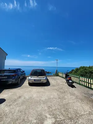two cars parked in a parking lot near the ocean at Apartment Ulcinj in Ulcinj