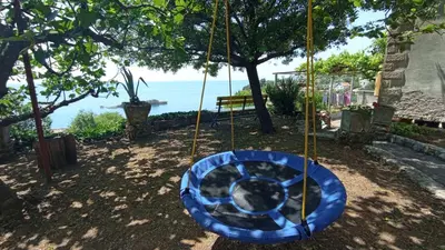 a swing in a yard with the ocean in the background at Apartment Ulcinj in Ulcinj
