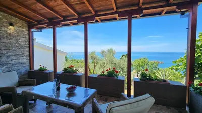 a patio with a table and chairs and a view of the ocean at Apartment Ulcinj in Ulcinj