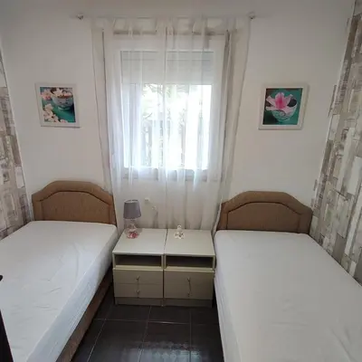 two twin beds in a room with a window at Holiday home Sutomore in Sutomore