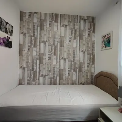 a bed in a room with a wall with at Holiday home Sutomore in Sutomore