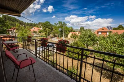 a balcony with two chairs and a table and a view at Apartman Damjanovic in Cetinje
