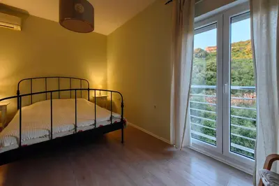 a bedroom with a bed and a large window at Apartment SeaView in Utjeha