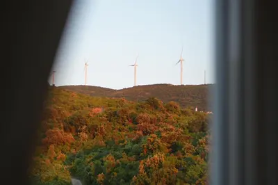 a view of a hill with wind turbines on it at Apartment SeaView in Utjeha