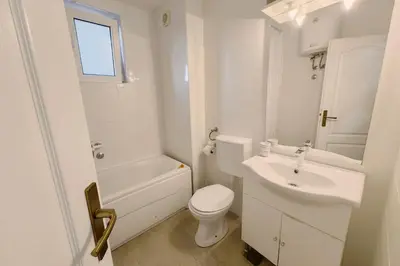 a white bathroom with a toilet and a sink at Apartment SeaView in Utjeha