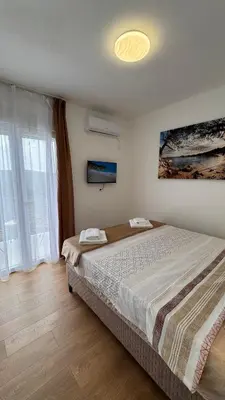 a bedroom with a large bed and a large window at Villa Aurora in Gorovići