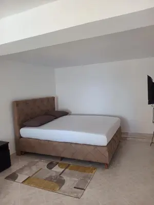 a bed in a room with a white wall at Jasmin 2 in Ulcinj