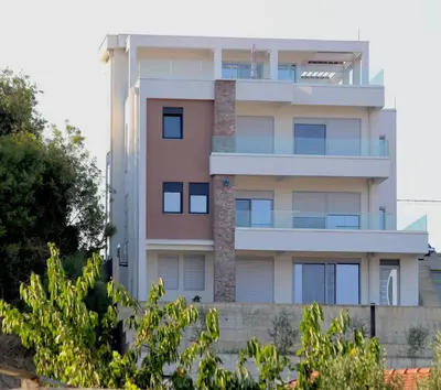a tall building with trees in front of it at Gjerana SEAVIEW in Ulcinj
