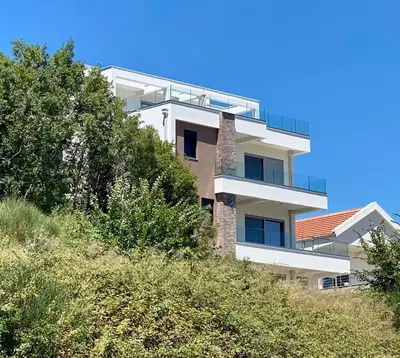 a white building on top of a hill with trees at Gjerana SEAVIEW in Ulcinj